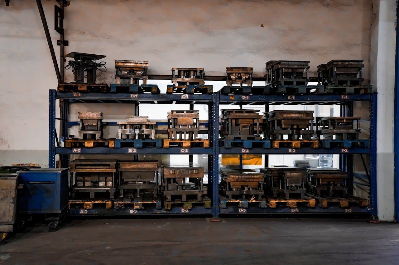 who-we-are Metal molds neatly arranged on industrial shelving in a warehouse setting, showcasing order and efficiency.